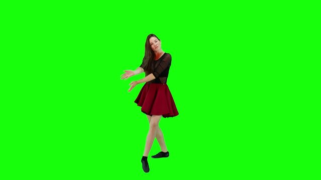 Happy young woman slowly dancing and smiling in a green screen background