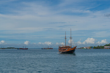 Obraz premium View from the ferry to Waisai at Sorong with cruises and tour boats, background blue sky, copy space