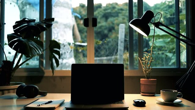 laptop with black screen For example on a playlist a song or music for use media video, workspace, lamp, on the table with hot coffee and music headphones on the table, a window in the background.