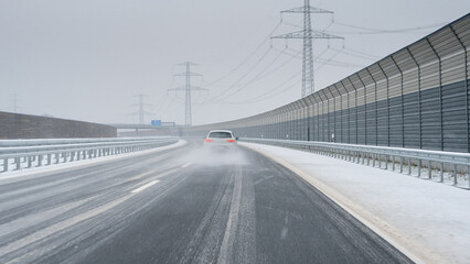 Car overtaking another car on a icy road (German Autobahn). Symbol for dangerous driving on a slippery road.