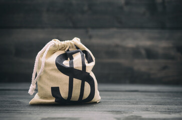Dollar money bag on the black wooden background