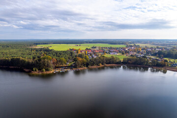 Aerial shot of beautiful lake surrounded by forest in a calm autumn day. Germany.