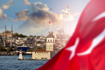 Maiden's Tower among flying seagulls in Bosphorus, Istanbul, Turkey, Behind of blurred national flag of Turkey.