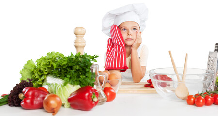 little cute chef holding wooden spoon with different pair of gloves looking at camera and smiling on gray background