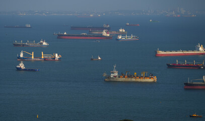 Singapore harbour from above. Aerial view of a lot of cargo vessel ships waiting on the sea in Singapore industrial cargo bay, 2023.