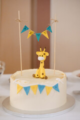 Birthday cake with giraffe and flags on a white background.