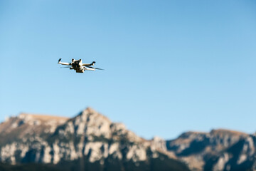 Fototapeta na wymiar Drone flying over mountains top on blue sky background.