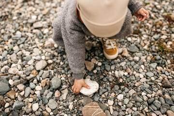 Child playing with rocks and pebbles, outdoors.