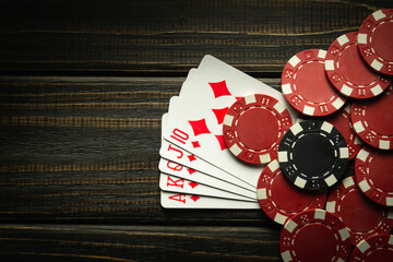 Playing cards with a winning combination of royal flush and chips on a black vintage table in a...