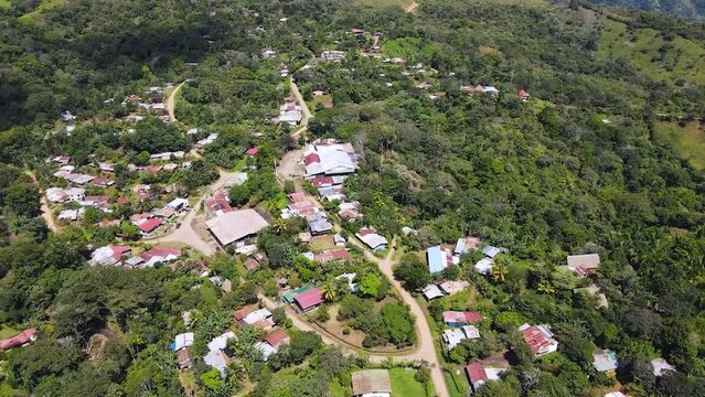 A town in the Boruca community, Costa rica, with sparse houses near the mountain. Aerial drone shot, rotating tracking movement.
