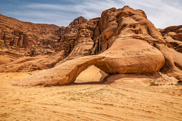 Natural arch formation on a big rock in Wadi Rum desert. Jordan
