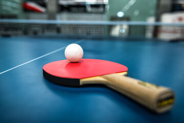 Ping pong table, racket and ball in a sport hall