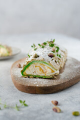 Meringue roll cake, roullade, roll with pistachio and lemon curd cream decorated with pistachio and thyme. Pavlova summer dessert with cream