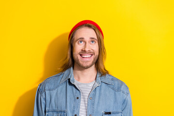 Photo of funky excited guy dressed jeans shirt looking up emtpy space isolated yellow color background