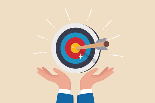 Goal or target, focus and concentration to achieve success, purpose or objective, aiming at target bullseye, accuracy, challenge and aspiration, businessman hand hold target with arrow hit bullseye.