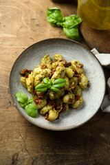 Homemade potato gnocchi with pesto and tomatoes