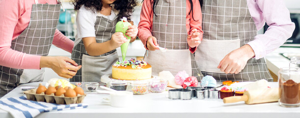 Portrait of enjoy happy love asian family father and mother with little asian girl daughter child play and having fun cooking food together with baking cookie and cake ingredient in kitchen