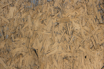 Brown or yellow OSB board texture. Wooden background. Pressed chipboard pattern. Chip board background. Brown wood texture