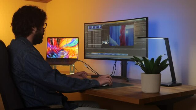 Filmmaker editor busy working on media project at cosy studio desk at home