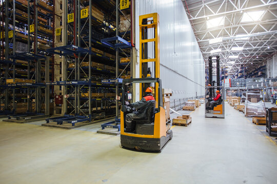 Forklift loader in Modern warehouse interior with shelves and boxes