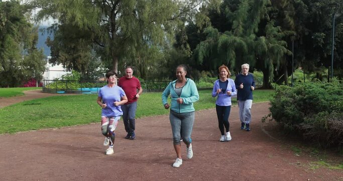 Fit senior people running at city park - Group of elderly friends doing sport workout together outdoor 
