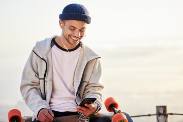 Skateboarder, phone and man streaming music, audio or podcast online and relax after skating with mockup and texting. Skater, skateboard and person listening to mobile radio in sunset on social media © Malik/peopleimages.com
