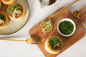 savory puff cups with ham, mushroom and vegetables, selective focus