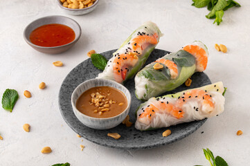 Summer rolls with fresh vegetables and shrimps and peanut sauce. Vietnamese appetizer. Salad spring rolls with prawns. Healthy food concept