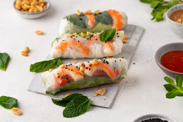 Summer rolls with fresh vegetables and shrimps and peanut sauce. Vietnamese appetizer. Salad spring rolls with prawns. Healthy food concept