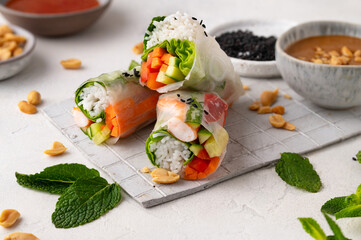 Summer rolls with fresh vegetables and shrimps and peanut sauce. Vietnamese appetizer. Salad spring...