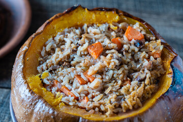Great pumpkin baked with a filling close up. Stuffed roasted orange pumpkin, whole baked, filled with a tasty mixture of rice, raisins and spices