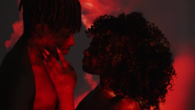 Love blossom. Beloved couple. Double exposure people. Sensual black man and woman looking each other posing on dark shadow red splashes overlay background.