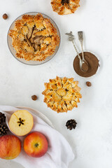 Homemade apple pies with fresh apples and cinnamon on a light background. Traditional autumn Thanksgiving dessert. Top view
