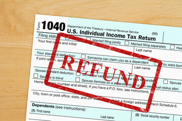 Refund message with US federal 1040 tax return form on a desk