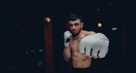 Closeup white Gloves for MMA of Boxers fighter in octagon. Concept kickboxing sport banner, dark...