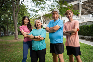 Healthy family group instructors workout in fresh air, and they rest and stand together after morning exercises in park. Outdoor activities, healthy lifestyle, strong bodies, fit figures, health care.