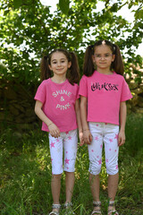 Fototapeta premium Ritratto di sorelle gemelle di 8 anni in mezzo agli alberi.