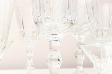 Closeup of crystal glasses in front of beige background.