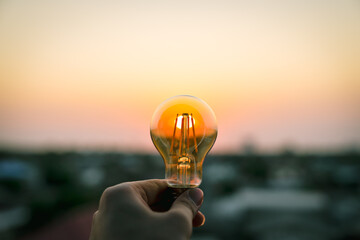 Hand business man holding light bulb. Alternative energy, idea, saving electricity innovation and...