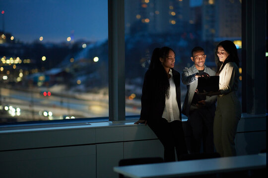 Colleagues working late in office - Powered by Adobe