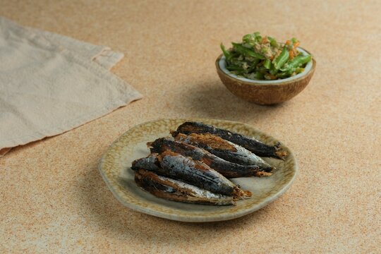 Fried fish cooked at home. Ikan besek goreng. Orak arik beans in the back. Indonesian food