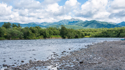 Blue river flows under an azure sky. A sunny summer day. Kamchatka