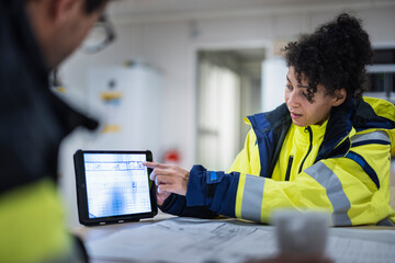 Construction engineers discussing project in office