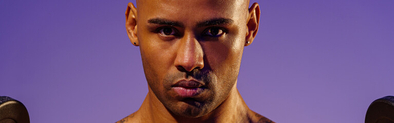 Obraz premium Close up of man doing exercise with weight dumbbells on studio background. Strength and motivation