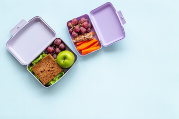 Healthy lunch boxes filled with fruits and vegetables, top view