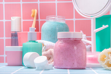 Bath background with cosmetics, cream, scrub, toothbrush, serum, mirror pink and blue tiled bright background. Cute bright self care, spa, relax, time for yourself concept
