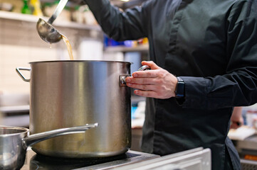 chef cooking soup on restaurant kitchen