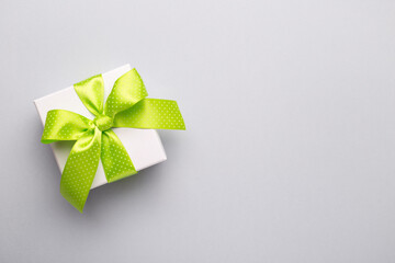 White gift box with green ribbon