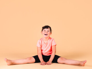 Obraz premium elementary girl exercising on beige background