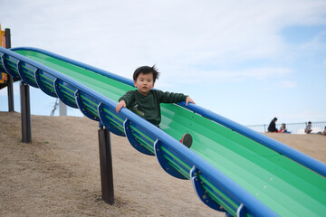 すべり台で遊ぶ男の子